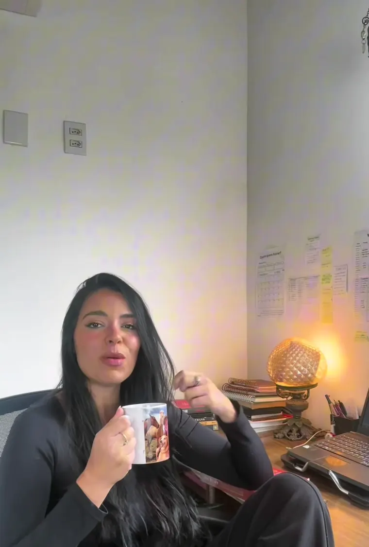 Mary gravando no escritório, com caneca na mão