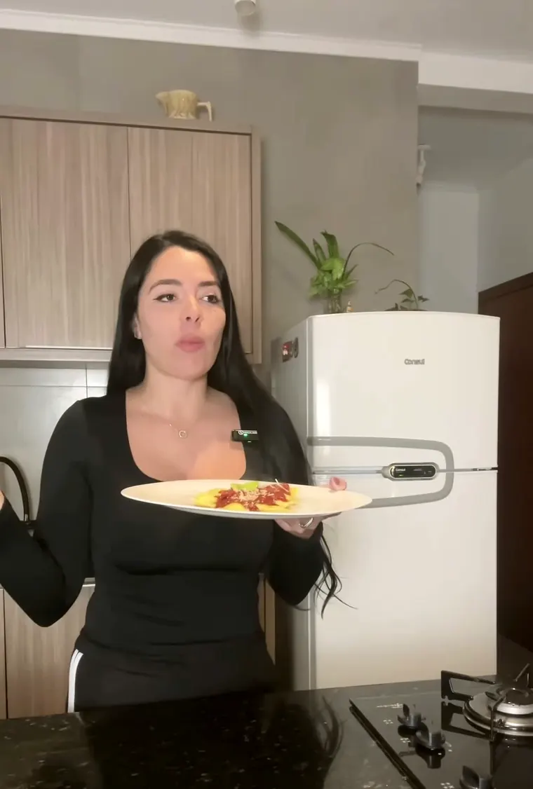 Mary apresentando um prato de massa da Casa Leni